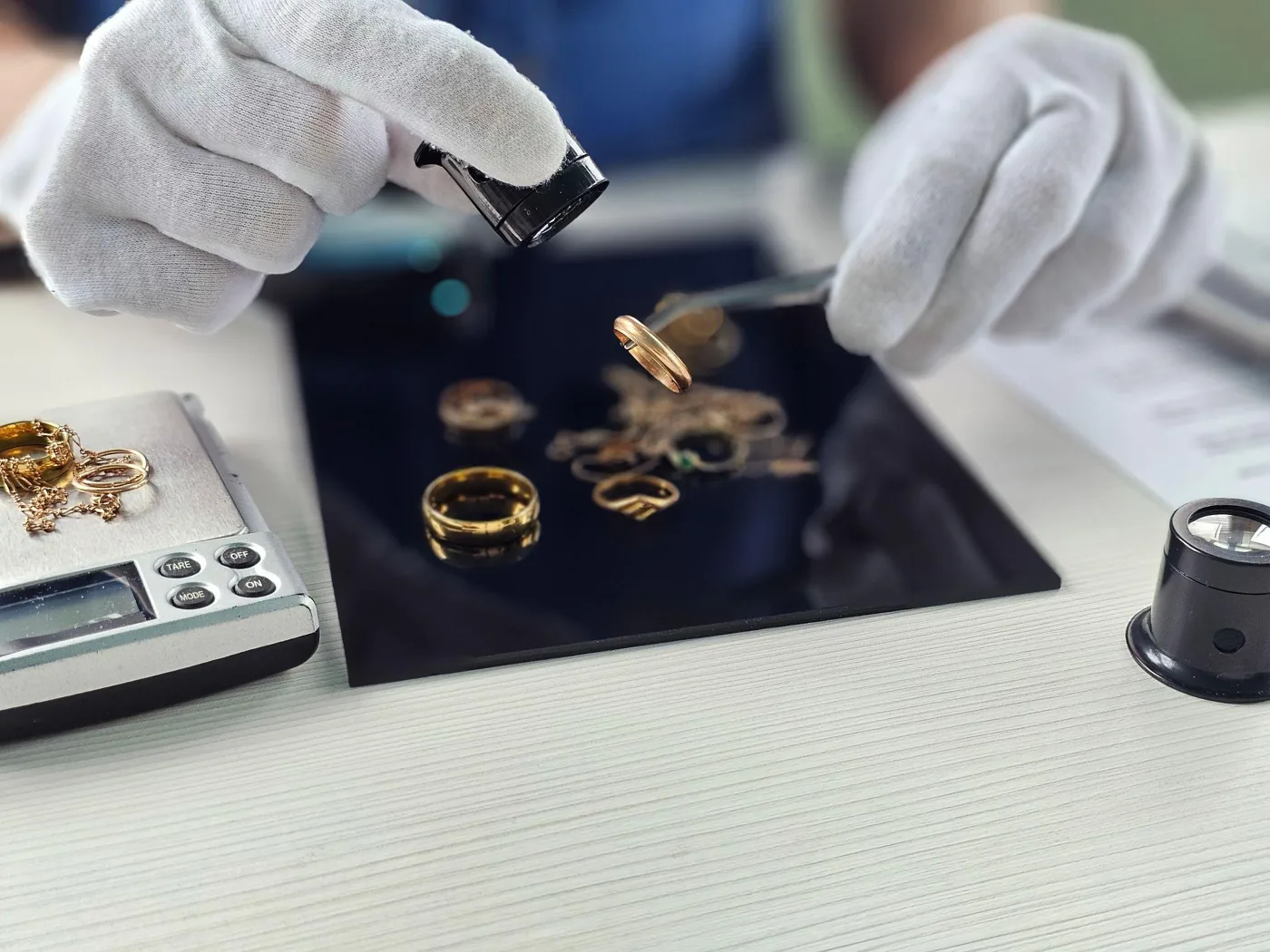 Professional appraiser examining gold with a loupe and scale